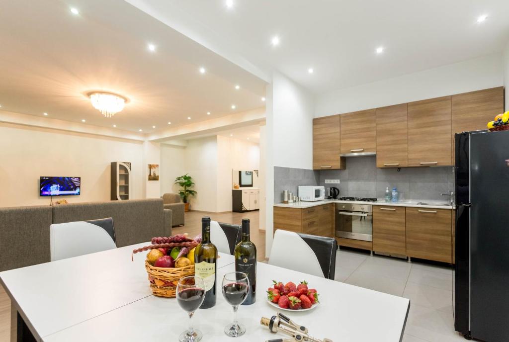 une cuisine et une salle à manger avec une table et des verres à vin dans l'établissement The Grand Apartment l, à Tbilissi