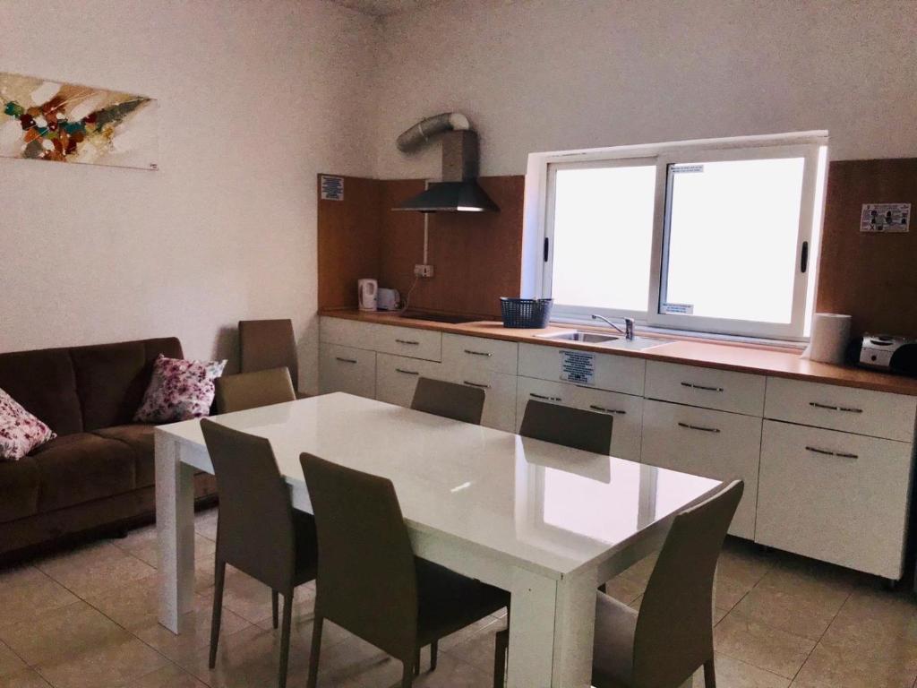 a kitchen with a white table and chairs in a room at Point Elyseum Apartament in St Julian's