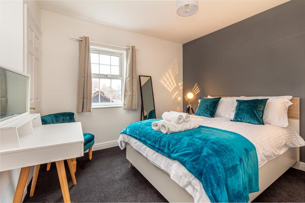 a bedroom with a bed and a desk and a television at Guest Homes - New Street Apartment in Worcester