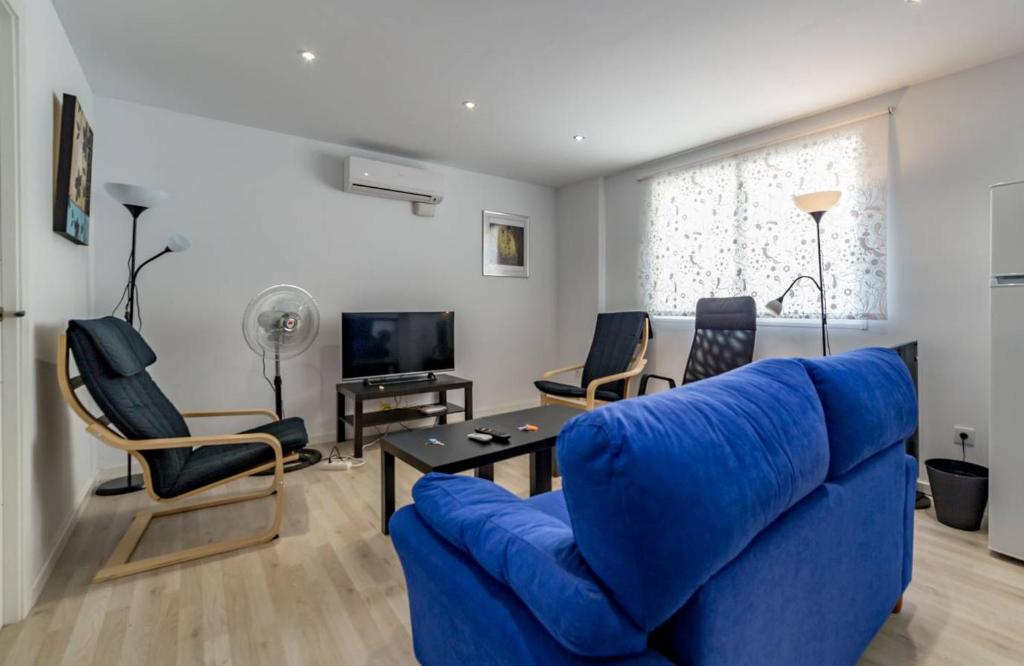 バレンシアにあるMalvarossa apartment near beachのリビングルーム(青いソファ、椅子付)