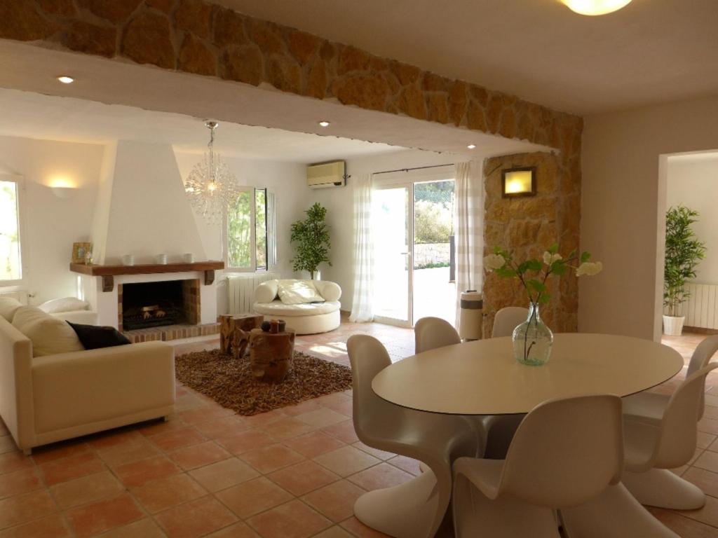 セス・パイセスにあるLavish Mansion Only 20 minutes from Ibiza Townのリビングルーム(テーブル、椅子、暖炉付)