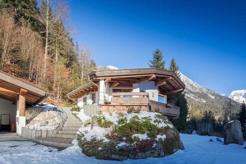 una casa de madera en las montañas en la nieve en Chalet Hinterstein en Scheffau am Wilden Kaiser