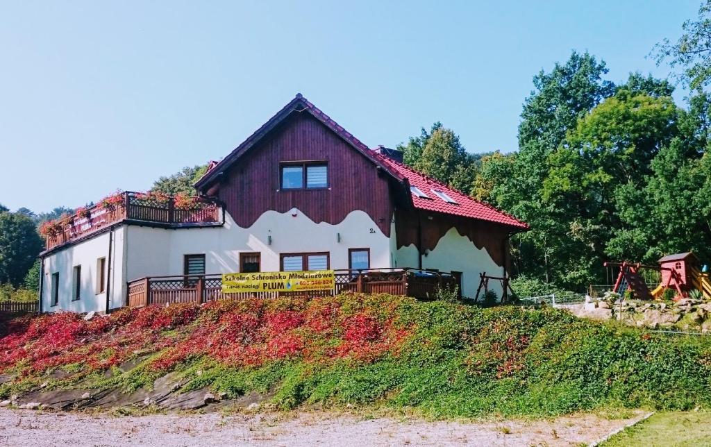 a barn on top of a grassy hill at Szkolne Schronisko Młodzieżowe PLUM in Piechowice