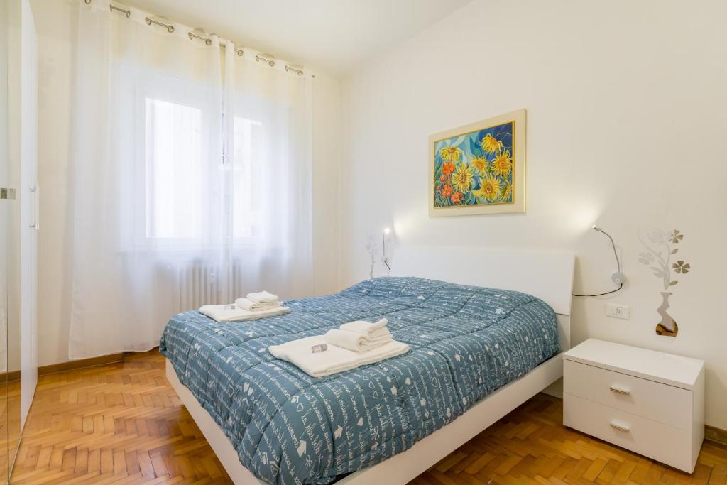 a white bedroom with a bed and a window at Casa Giulietta in Verona
