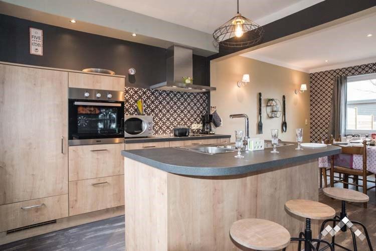 a kitchen with a counter and some bar stools at Gîte citadin 3 épis "CARPE DIEM" in Bastogne