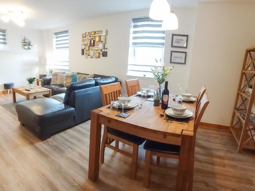 sala de estar con mesa y sofá en Inverness City Centre Apartment with Elevator and Google Chromecast, en Inverness