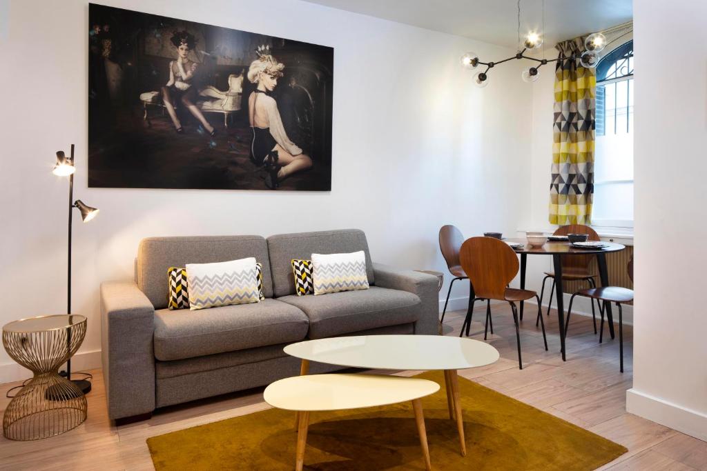 a living room with a couch and a table at Appartement rue de Rennes - Gaîté in Paris