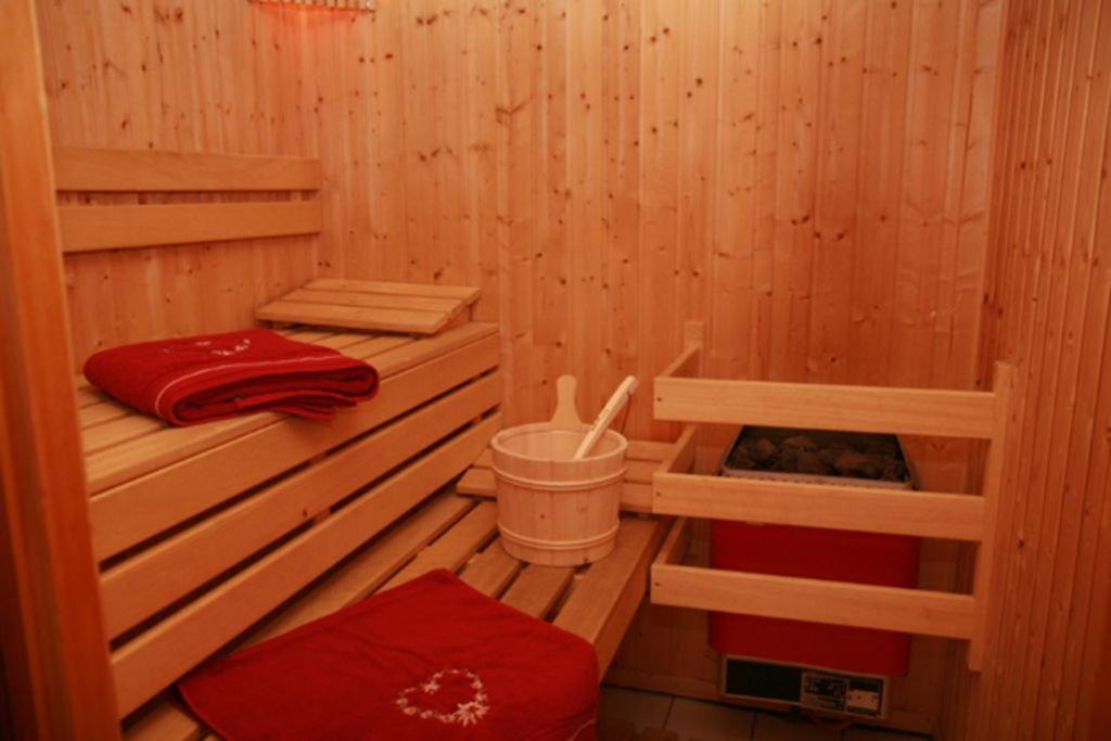 una sauna de madera con 2 camas y un cubo en La Tania La Saboia sleep 8 private Sauna lounge dining 2 bathrooms kitchen 2 balconies ski in out en La Tania