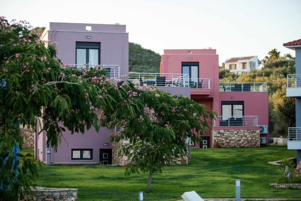 a row of pink and purple houses at Blue Waves Houses in Plomarion