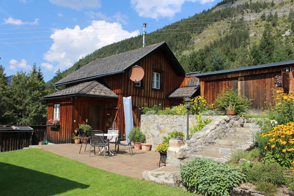 a wooden house with a table and chairs in front of it at Ferienhaus Margotti in Altaussee