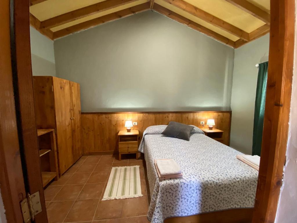 een slaapkamer met een bed en twee nachtkastjes bij Breñoso 2 in Puntagorda