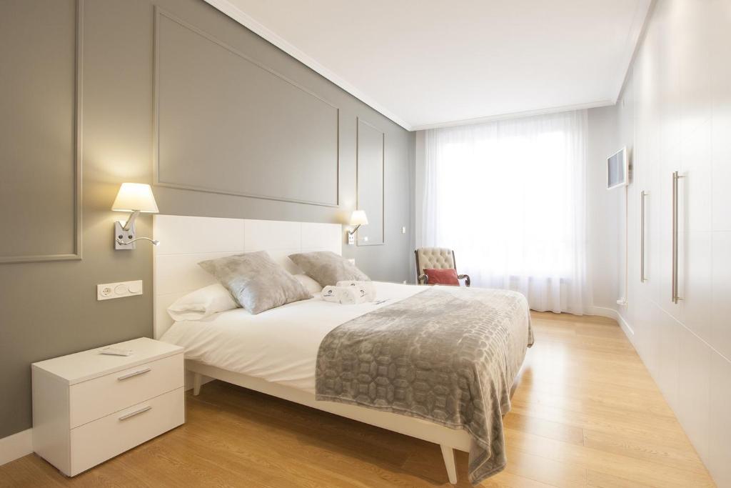 Un dormitorio con una gran cama blanca y una ventana en Gerezi - Basque Stay en San Sebastián