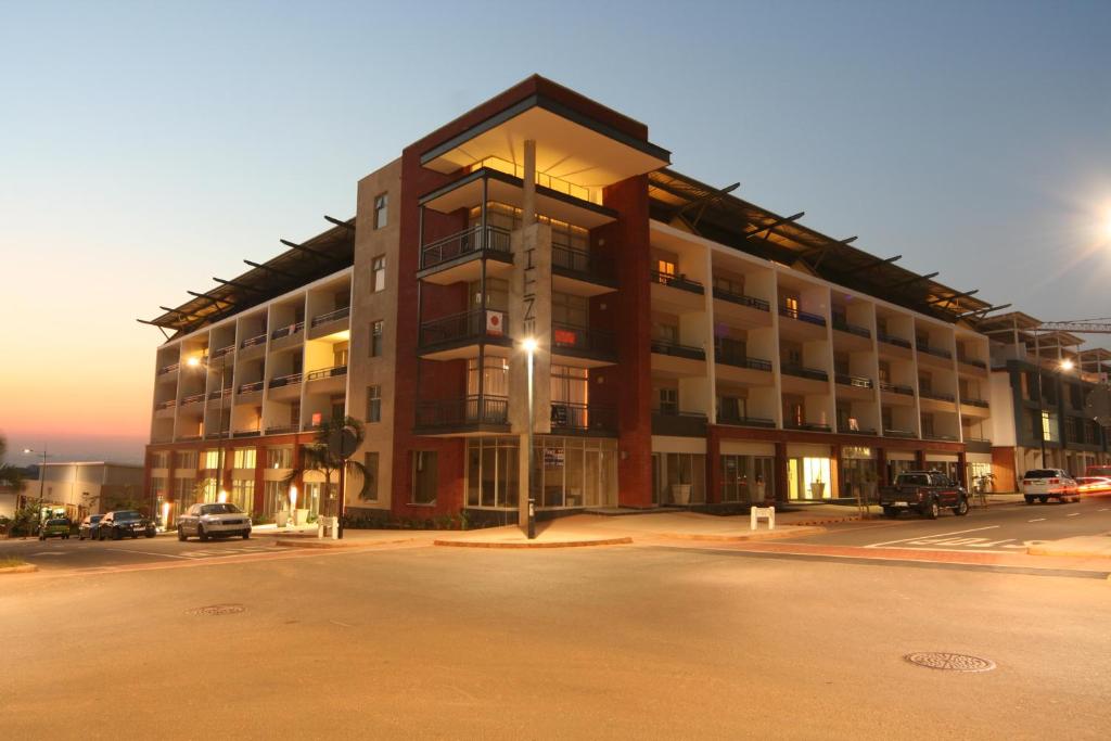 un gran edificio con un estacionamiento delante de él en La Loggia Gateway Apartments, en Durban
