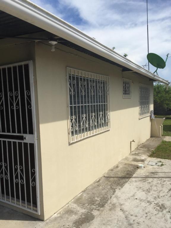 una casa con ventanas con barrotes y una puerta en Apartamento Cacao Changuinola, en Changuinola