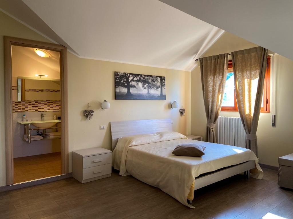 1 dormitorio con cama y espejo grande en La Dolce Sosta, en Campagnano di Roma