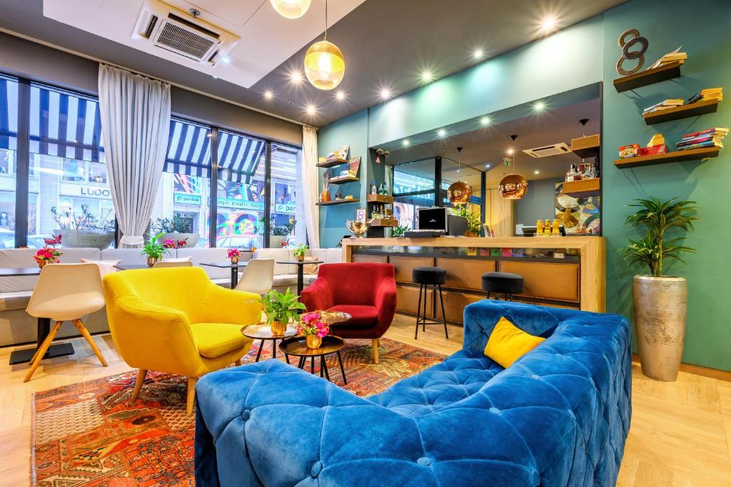 a living room with a blue couch and colorful chairs at Roombach Hotel Budapest Center in Budapest