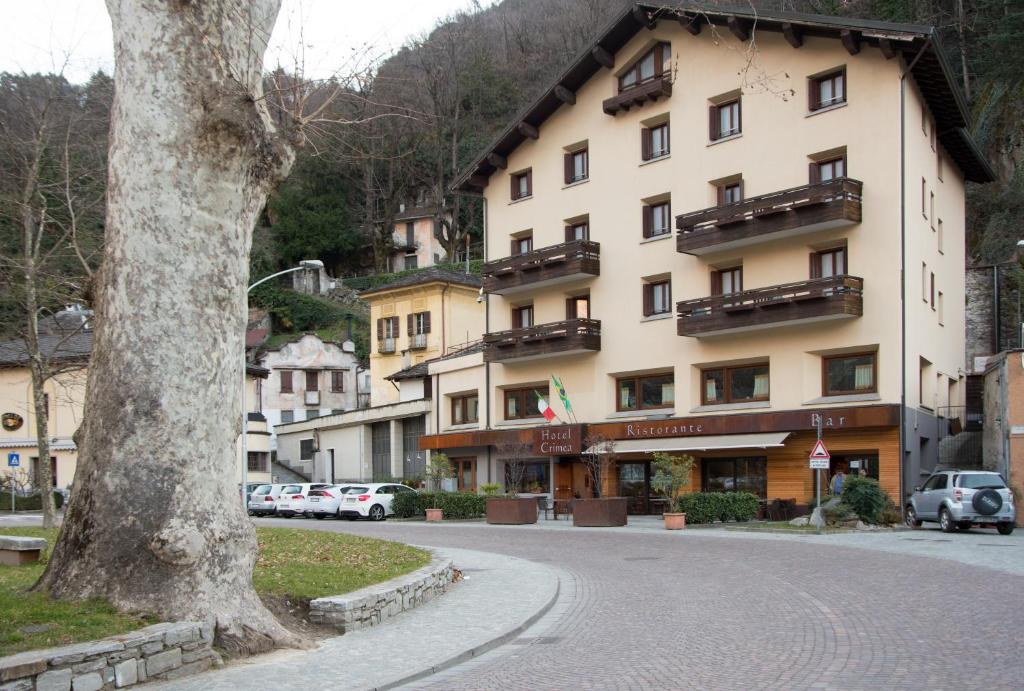 un grand bâtiment sur le côté d'une rue dans l'établissement Hotel Crimea, à Chiavenna