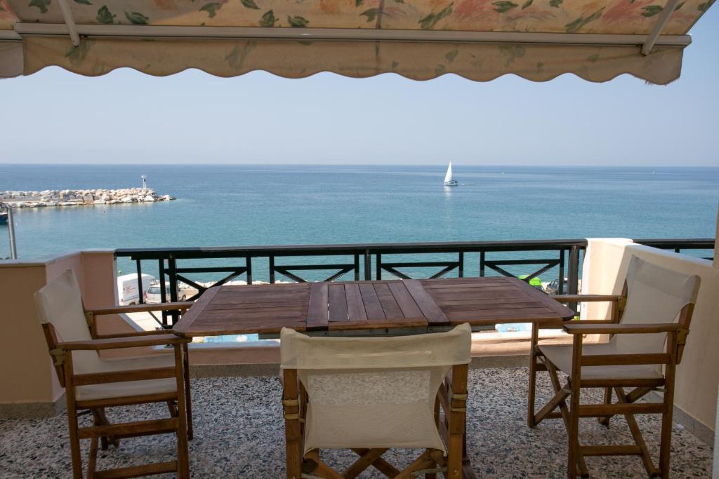 una mesa de madera y sillas en un balcón con vistas al océano en ELVETIA VILLA, en Potos