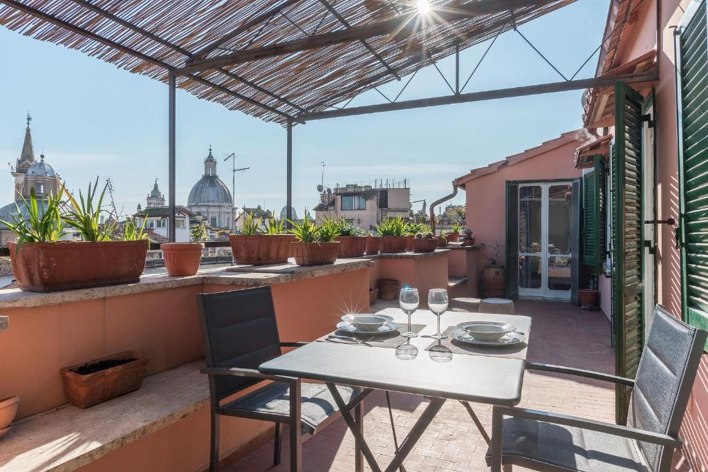 einen Tisch und Stühle auf einem Balkon mit Stadtblick in der Unterkunft Piazza Navona Panoramic Penthouse in Rom
