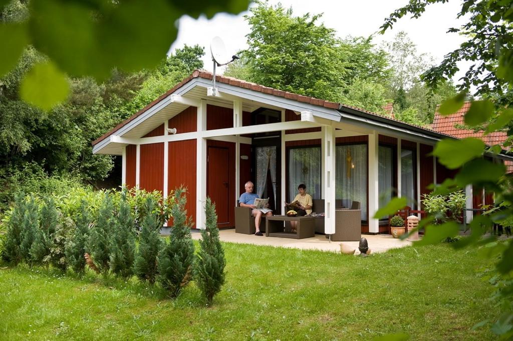 zwei Leute sitzen auf der Veranda eines Hauses in der Unterkunft Type Robinson in Ronshausen