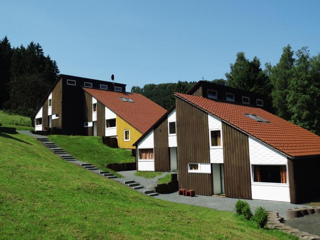 a row of houses on a hill with grass at Typ Fuchsbau in Schmallenberg