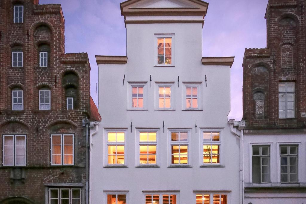 a white building with lights in the windows at Hotel Haase in Lübeck