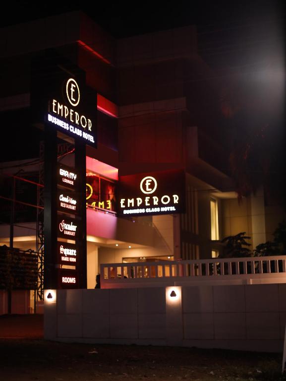 坎努尔Hotel Emperor的夜间在建筑物前的标志