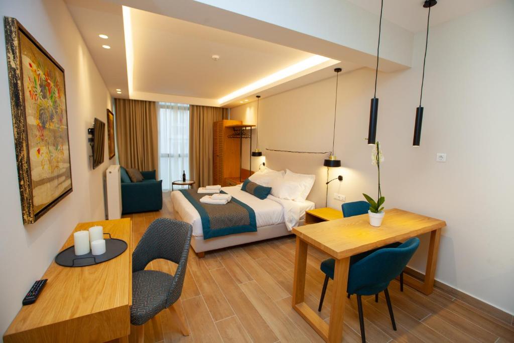 a hotel room with a bed and a table and chairs at No21 Luxury Suites in Thessaloniki