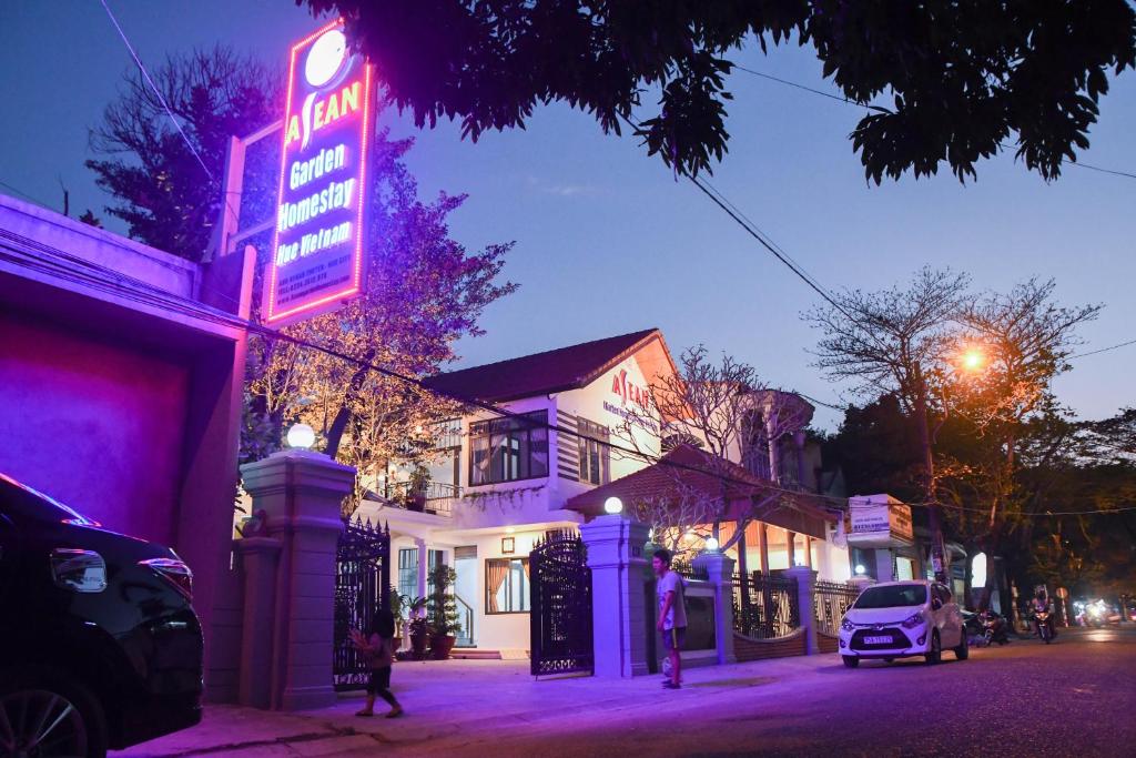 a neon sign for a restaurant on a street at night at Asean Garden Homestay Hue in Hue