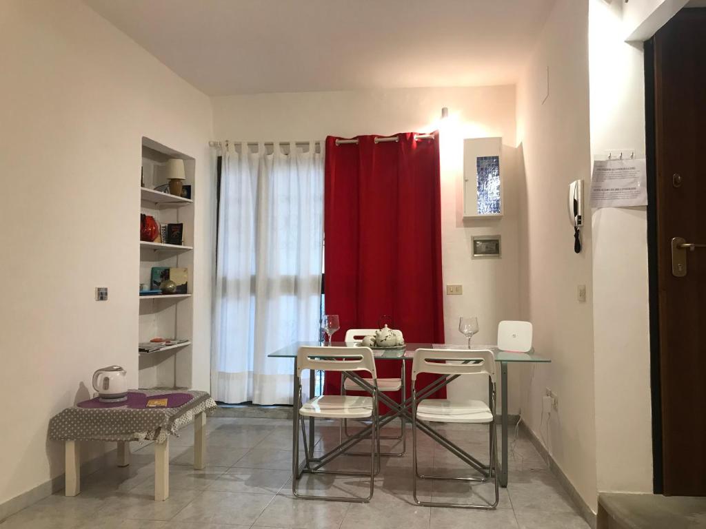 uma sala de jantar com uma mesa e uma cortina vermelha em Appartamento a due passi dal Duomo em Florença