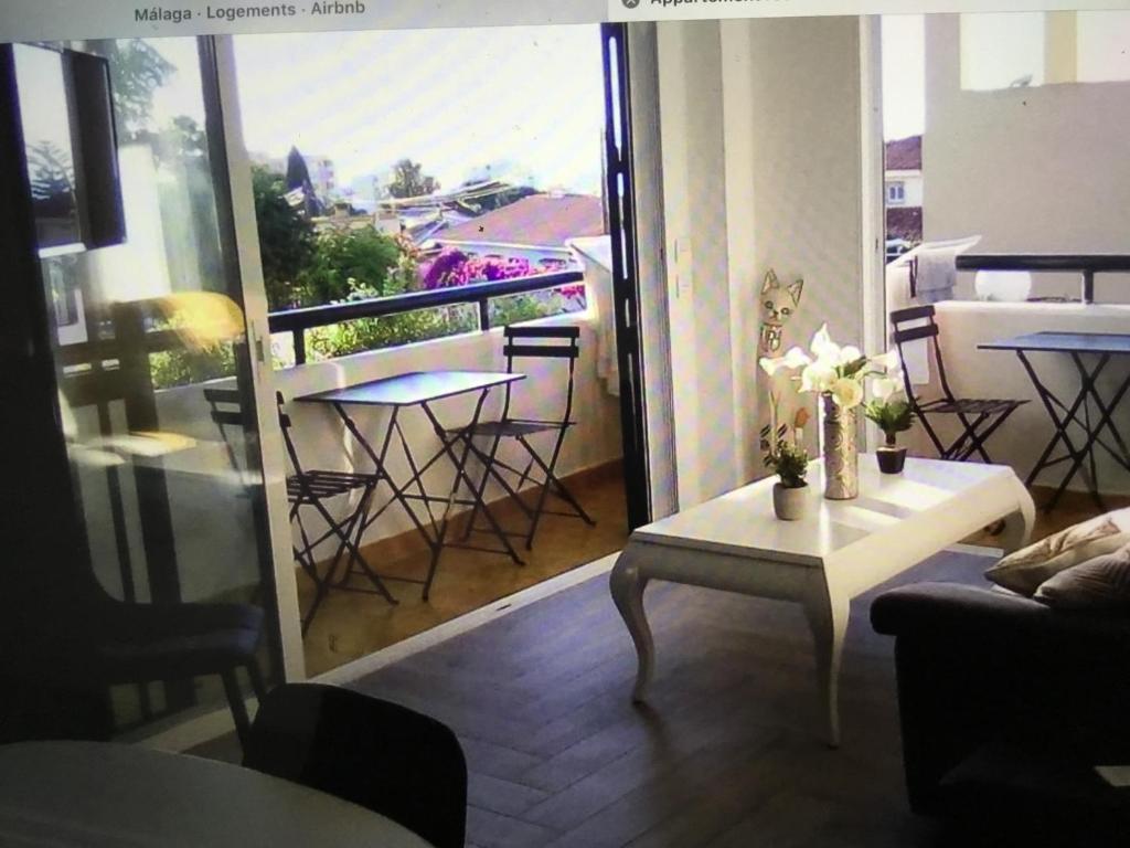 ein Wohnzimmer mit einem Balkon mit einem Tisch und Stühlen in der Unterkunft Appartement moderne pour 6 adultes in Benalmádena