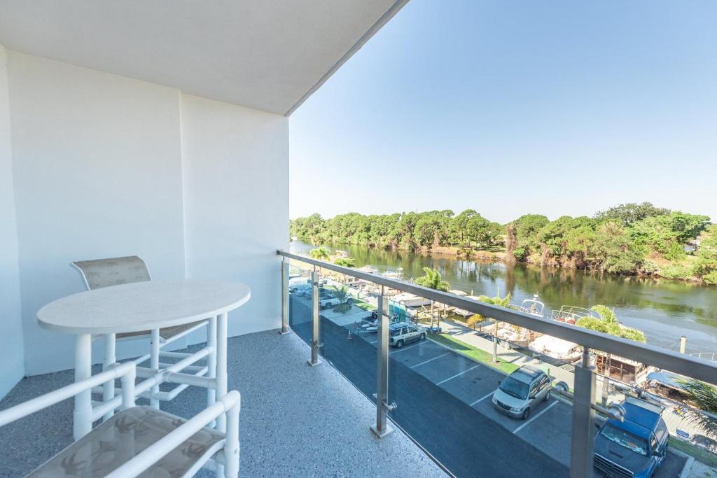 a balcony with a table and a view of a river at Cape Crossing Resort & Marina in Merritt Island
