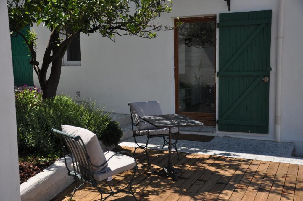 duas cadeiras e uma mesa em frente a uma casa com uma porta verde em 7 Avenue de Provence em Antibes