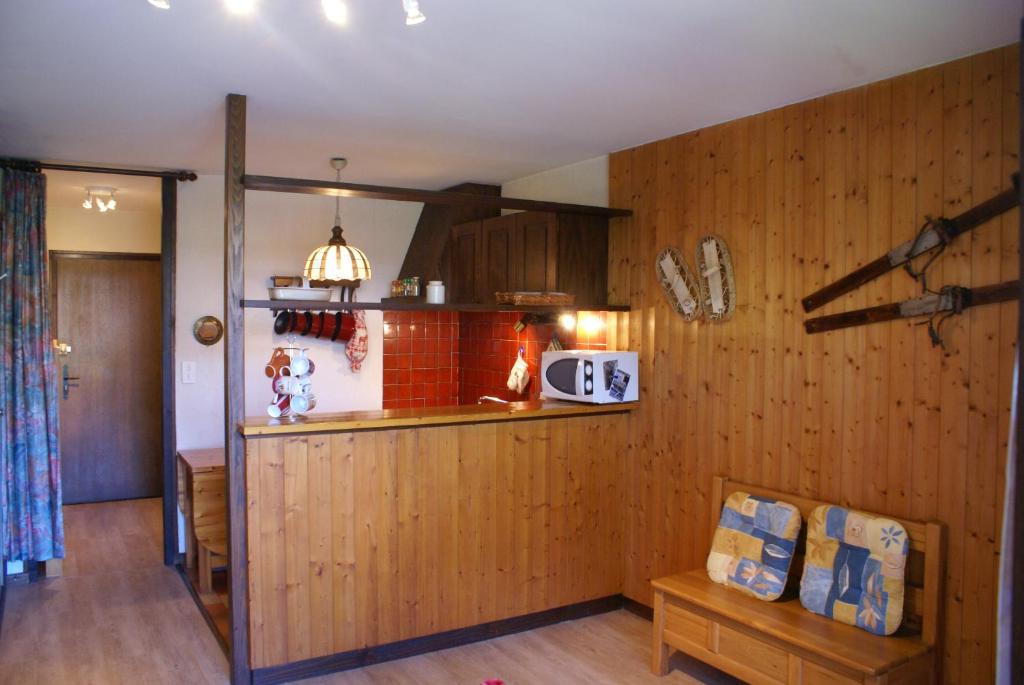 モルジヌにあるchamps de la Plagneの木製パネルの壁とカウンター付きのキッチン