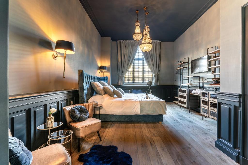 een slaapkamer met een bed, een stoel en een raam bij Castelsuites in Brugge