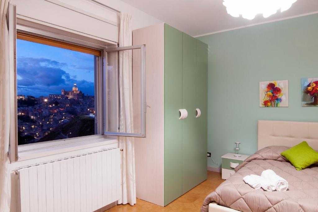 a bedroom with a bed and a large window at B&B Panorama in Piazza Armerina