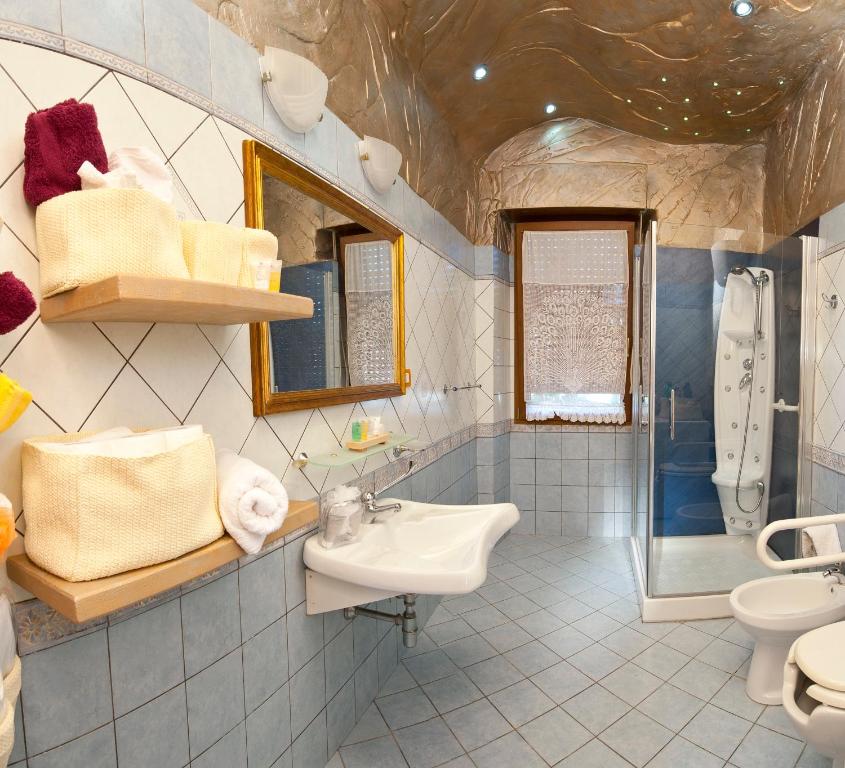 Un baño con lavabo, inodoro y ducha. en Domus de Janas Rooms Gonnesa, en Gonnesa
