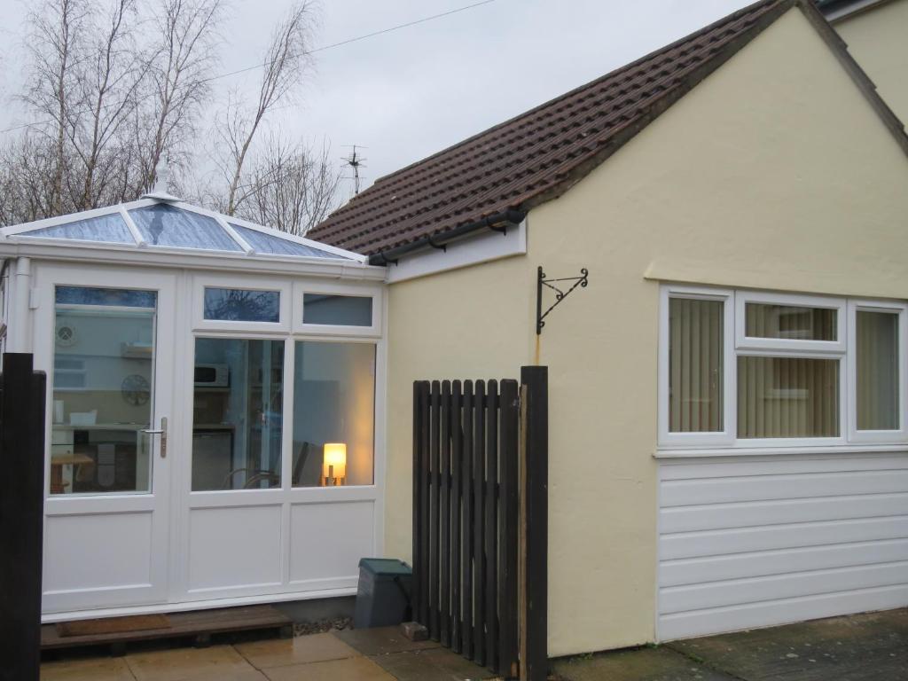 ein freistehendes Haus mit einer Garage und einem Solardach in der Unterkunft Little Orchard Apartment in Yate