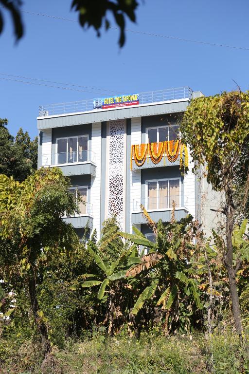 a white building with a sign on top of it at HOTEL YOG TAPOVAN- Rafting Available in Rishīkesh