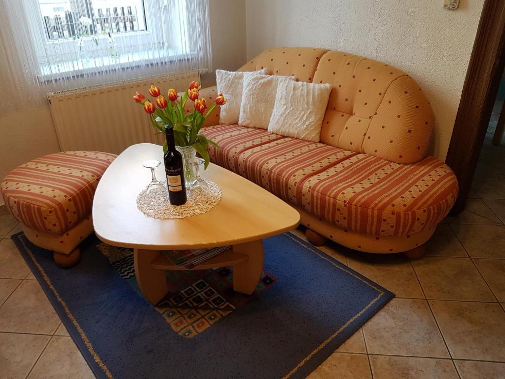 - un salon avec un canapé et une table avec une bouteille de champagne dans l'établissement Ferienwohnung Viola, à Meissen