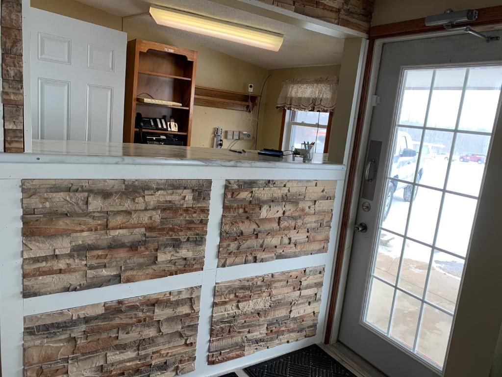 una cocina con una pared de piedra de imitación en una habitación en HOMETOWN INN, en Charles City