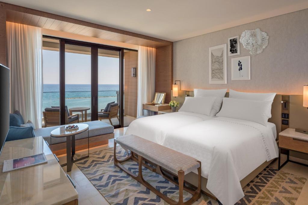 a bedroom with a large bed and a living room at Amara - Sea Your Only View™ in Limassol