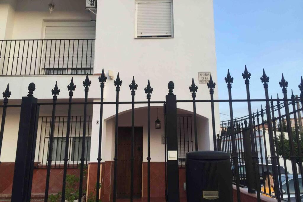 een zwart hek voor een huis met een deur bij Vacaciones Sierra Morena in Cazalla de la Sierra