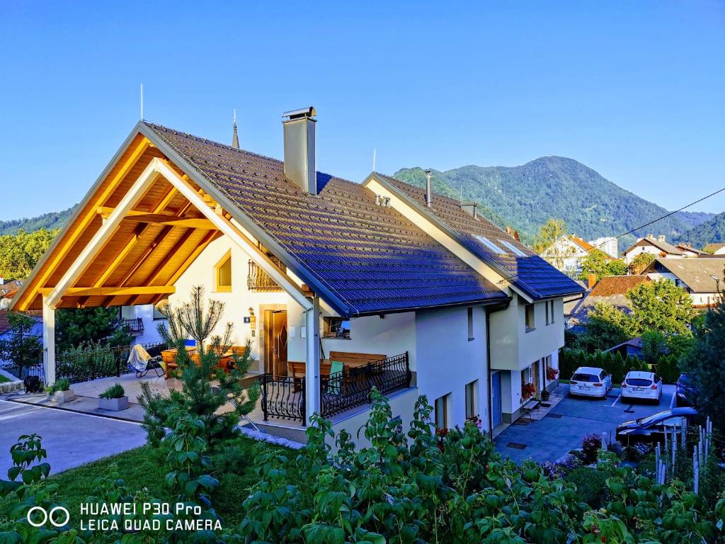 a white house with a blue roof at Tourist farm Megušar in Škofja Loka