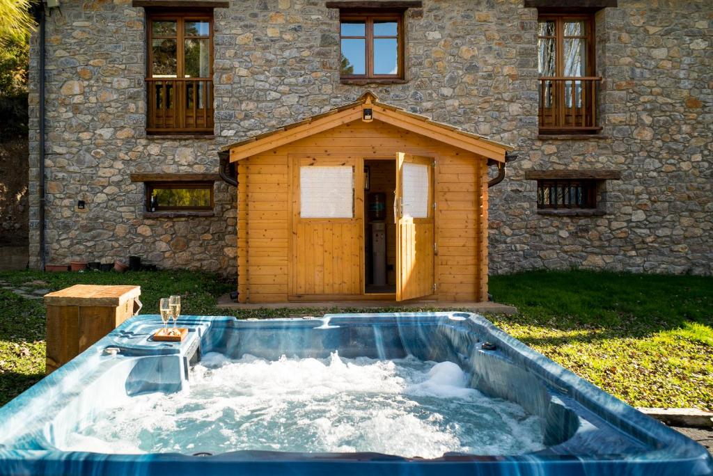 una piscina d'acqua di fronte a una casa di Casa Rural Molí de Fòrnols a Fornols