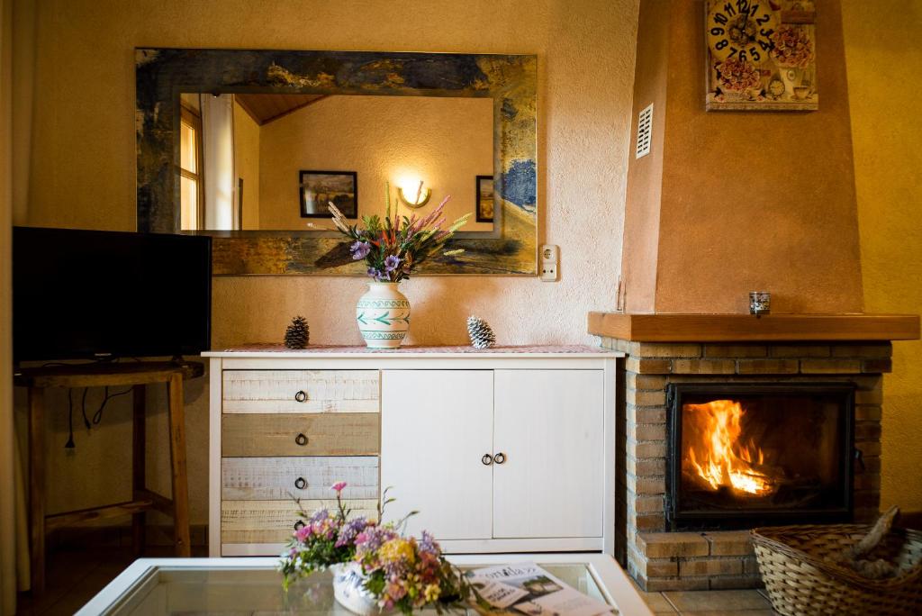 a living room with a fireplace and a mirror at Apartamento Molí de Fòrnols in Fornols