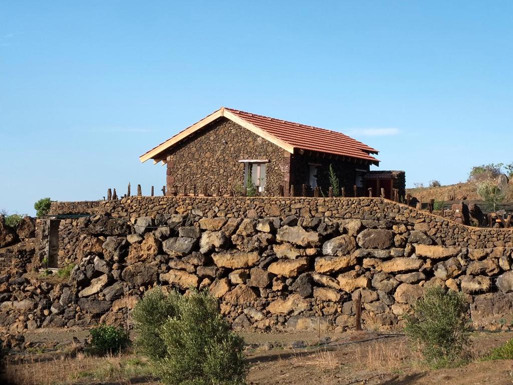 una casa en la parte superior de una pared de piedra en Casa Rural Los Santillos en El Pinar del Hierro