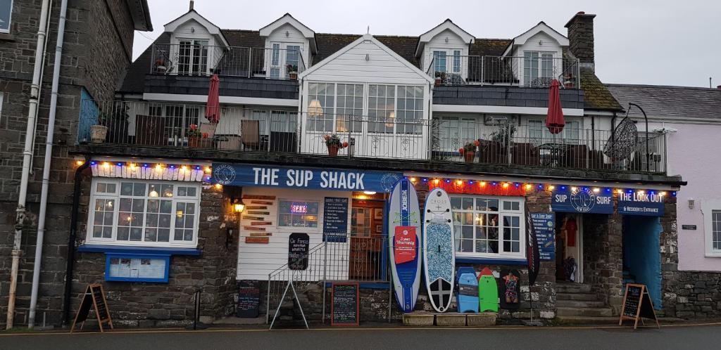 a building with a surf shop on the street at The Sup Shack Wellington Inn in New Quay