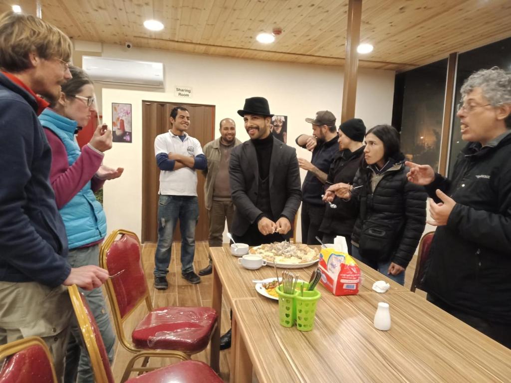 a group of people standing around a table at Petra Cabin Inn Hostel&Resturant in Wadi Musa