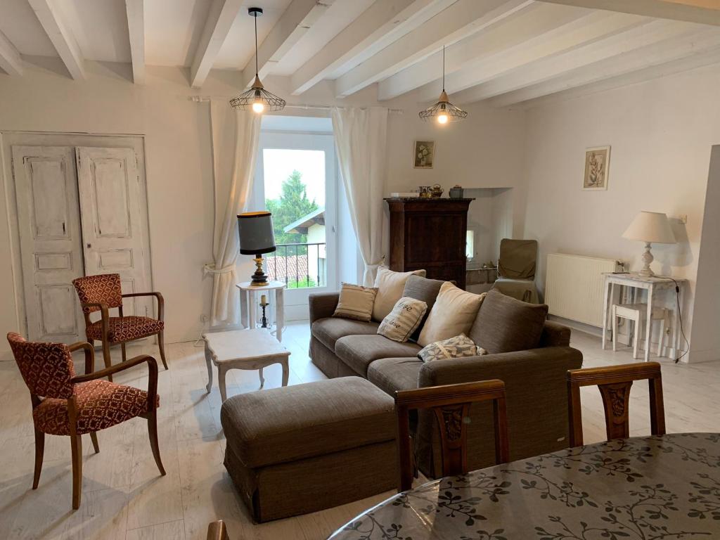 uma sala de estar com um sofá e uma mesa em maison de charme dans village médieval em Les Marches